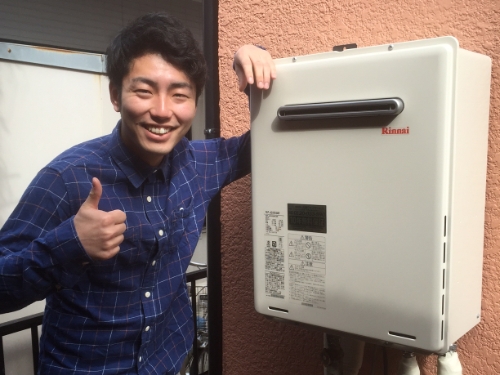 給湯器の横でグッドポーズするお客さま