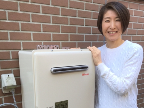 給湯器のそばでほほえむお客さま