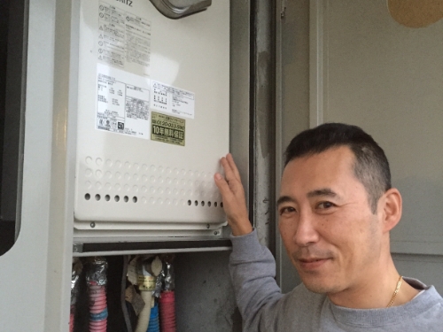 給湯器に触れて笑顔のお客さま